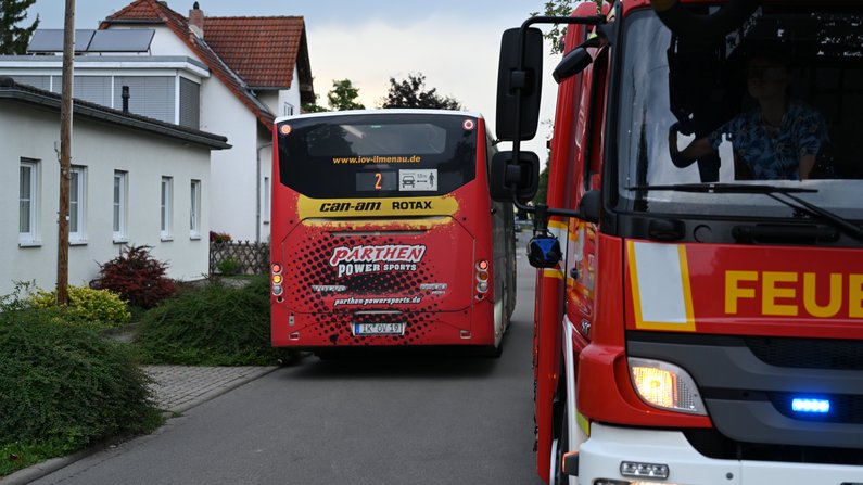 Auf dem Bild ist ein Feuerwehrauto mit einem Bus zu sehen. 