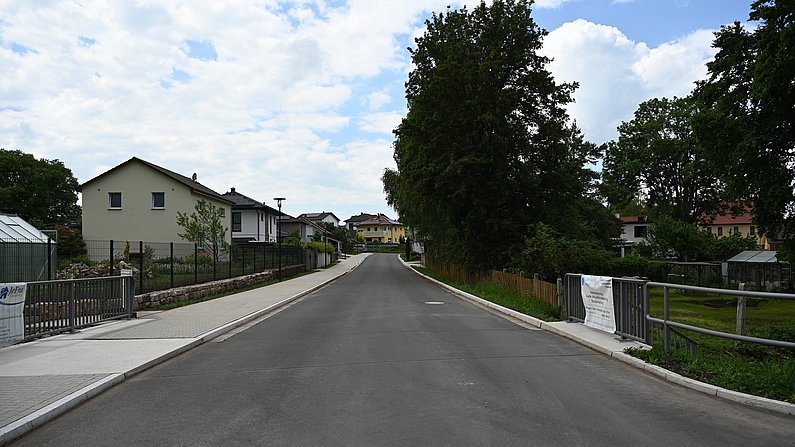 Auf dem Foto ist die neue Brücke und der ausgebaute Straßenabschnitt zu sehen. 