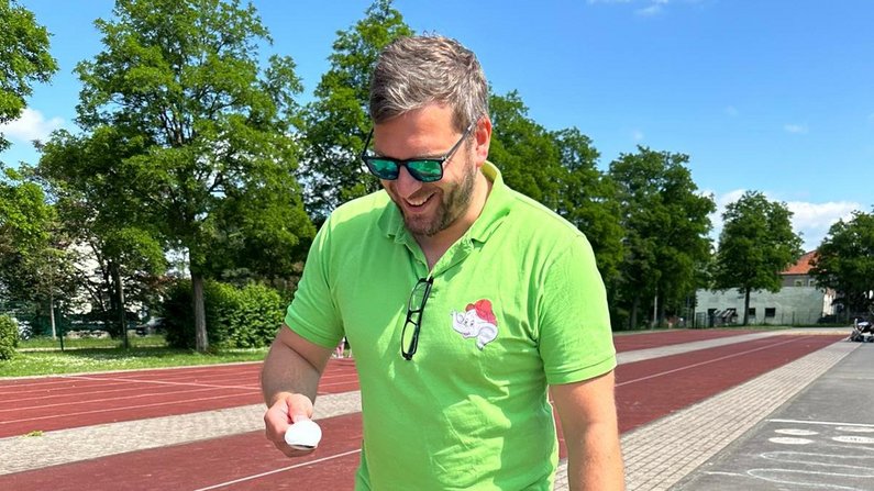 Auf dem Bild ist ein Erzieher beim Sportfest zu sehen. 